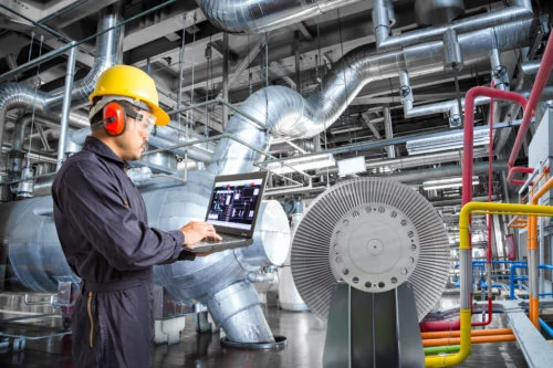 Engineer using laptop computer for maintenance in thermal power plant industrail